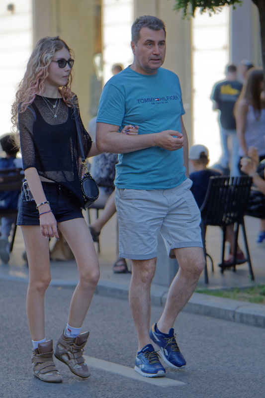 22 - Girl wearing a dark mesh long-sleeve top paired with black denim shorts and high-top sneakers